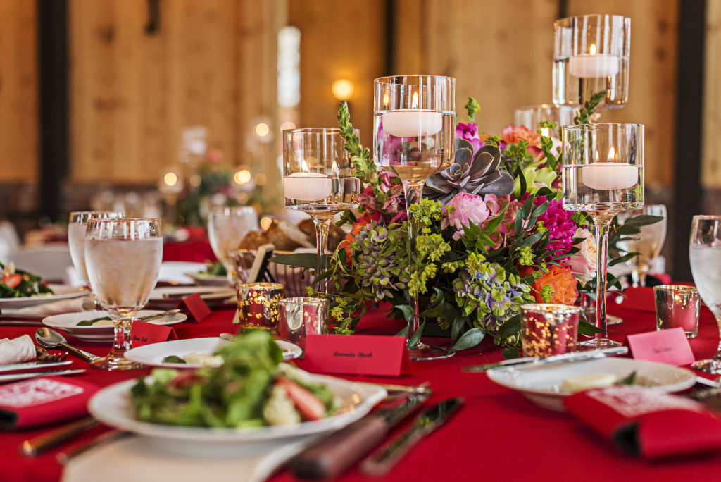Table decorations at Crooked Willow Farms, red linens and bright colored centerpieces with candles