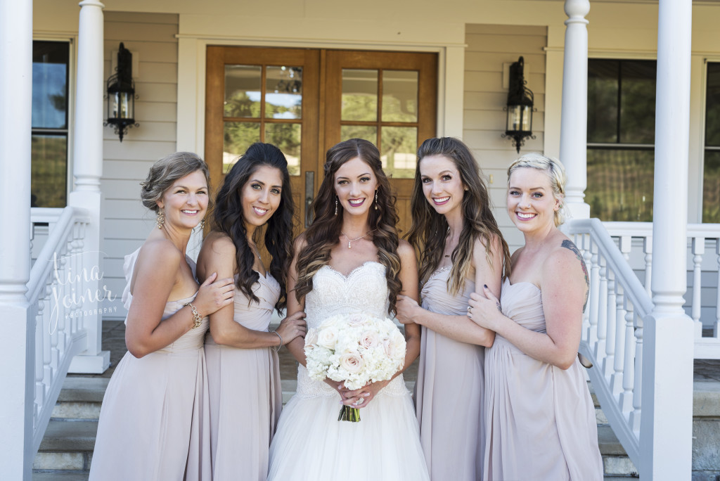Tara and her bridesmaids on her wedding day standing in front of the mansion at Flying Horse Ranch