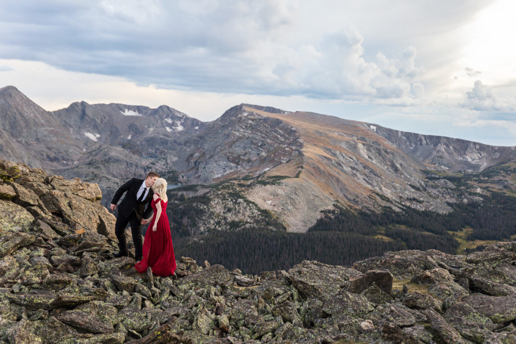 Kurtis leans in for a romantic kiss while walking with Mollie on a mountain top in Rocky Mountain National Park