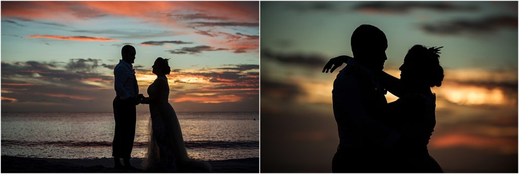 silhouette at sunset of bride and groom at the ocean