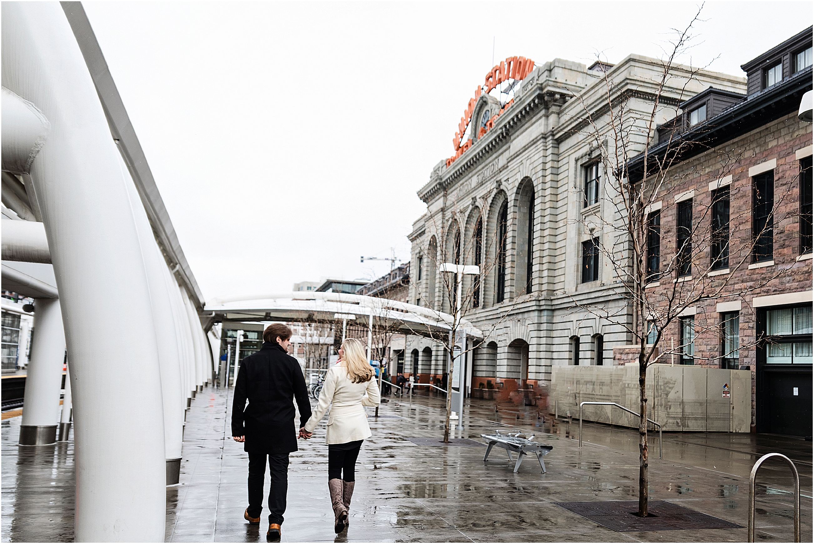 Couple walks on wet sidewalks behind union station in the winter