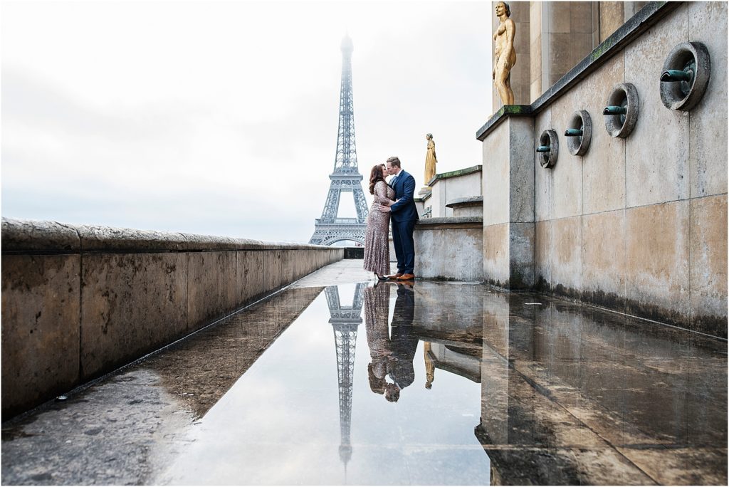Meghan and Joost kissing with Eiffle tower behind them and a stunning reflection at their feet.