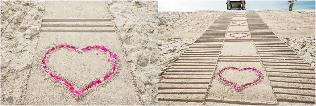 beautiful pathway in the sand with rose petals in heart shapes at destination wedding on beach