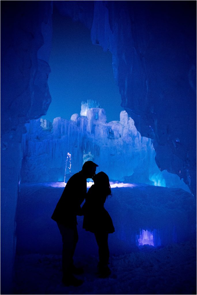 silhouette of a couple kissing with ice and snow behind them