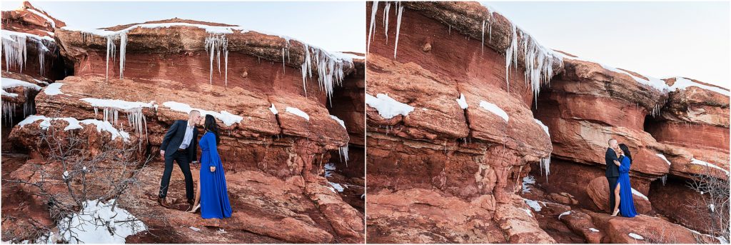 Engaged couple in formal clothes at Garden of the Gods with ice and snow all around them, they are holding hands and kissing in one image and he is kissing her forehead in the second image