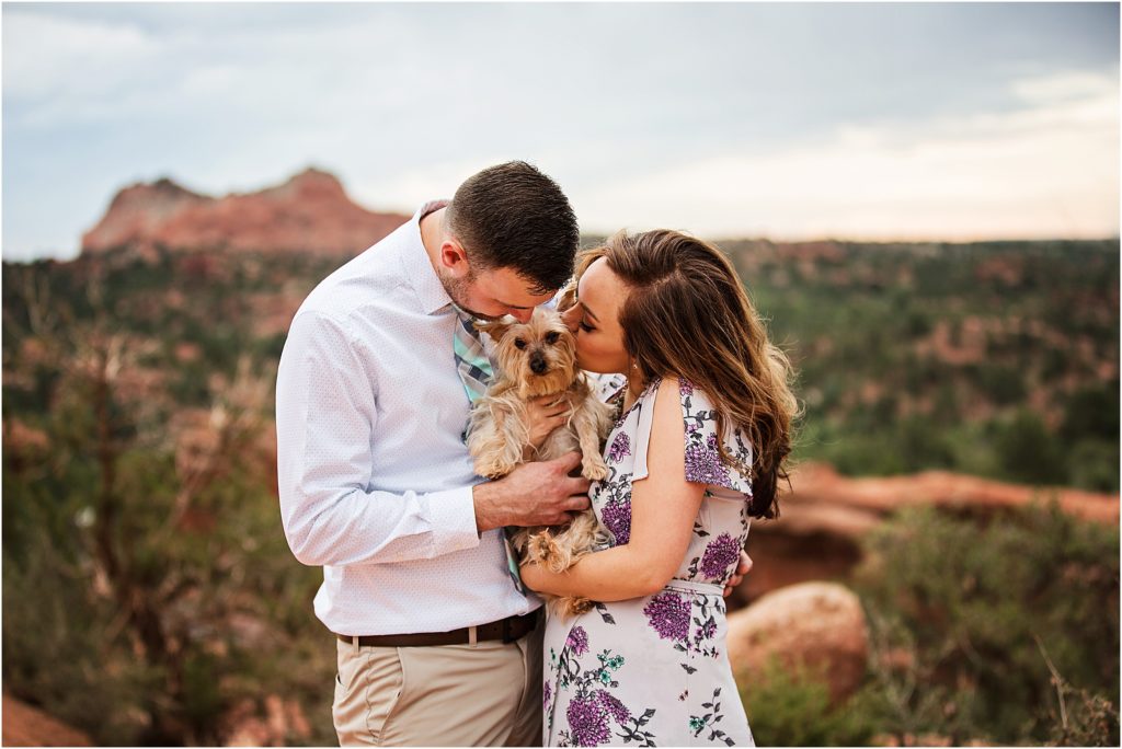 Cute couple cuddling and kissing their Yorkie dog at Garden of the Gods in Colorado Springs