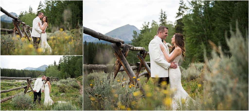 Bride and groom stand surrounded by yellow wild flowers and share a kiss while embracing.