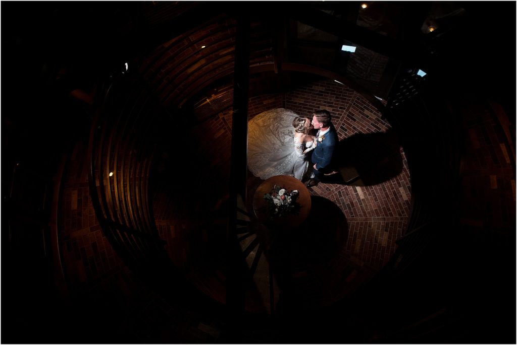 Bride and groom kiss in a wine cellar