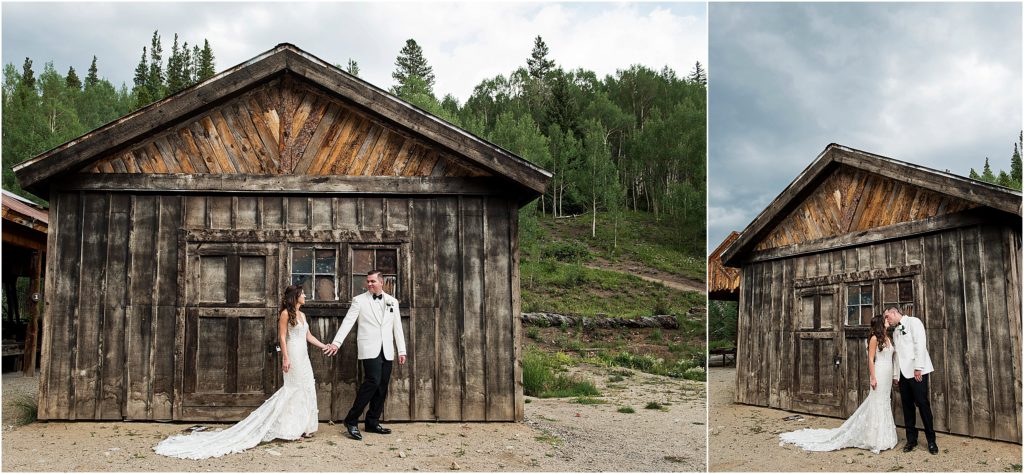Olivia and Steve hold hands in front of a rustic barn with a forest behind.