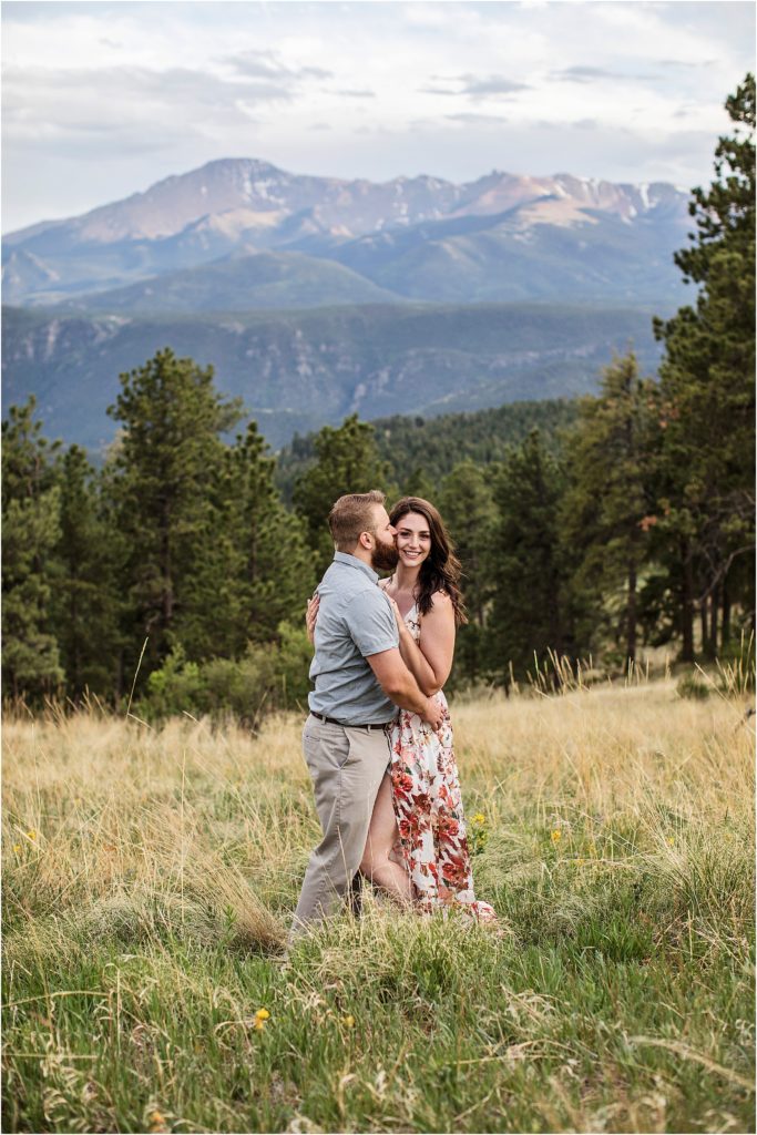 Couple embraces and Taylor kisses Paige with mountain views in Colorado