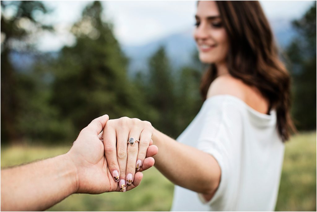 Paige leads Taylor by hand during their engagement session near Woodland Park