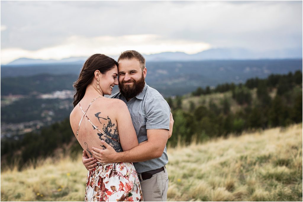 Paige shows off her back tattoo while Taylor embraces her during their engagement session.