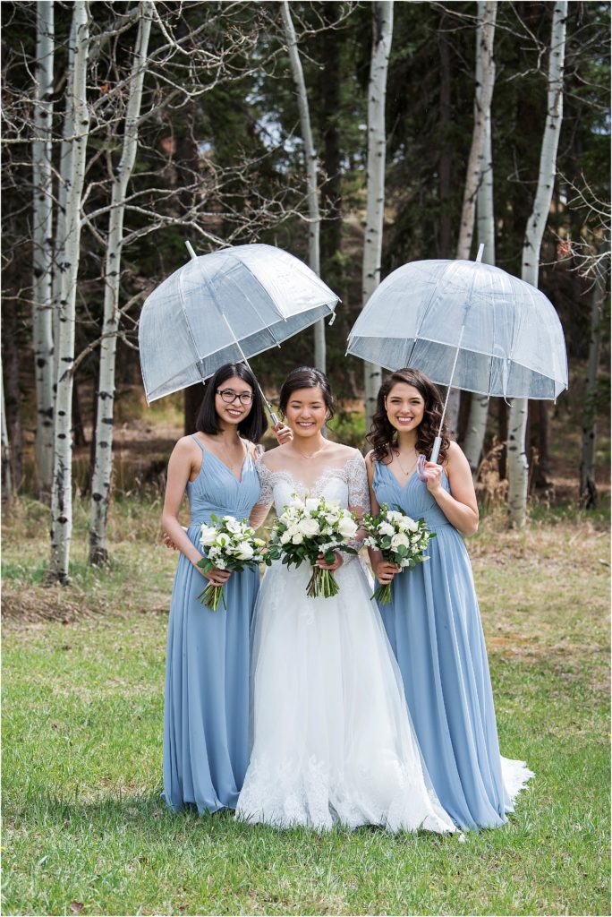 Emily and her bridesmaids in light rain on her wedding day.