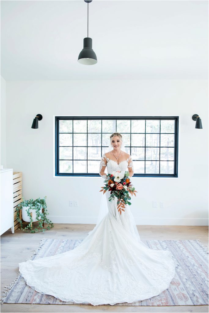 Bride stands is bright room at The Lofthouse in Colorado after getting ready for her wedding.