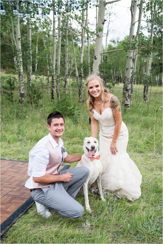 Derek and Breanda smile with their dog on their wedding day.