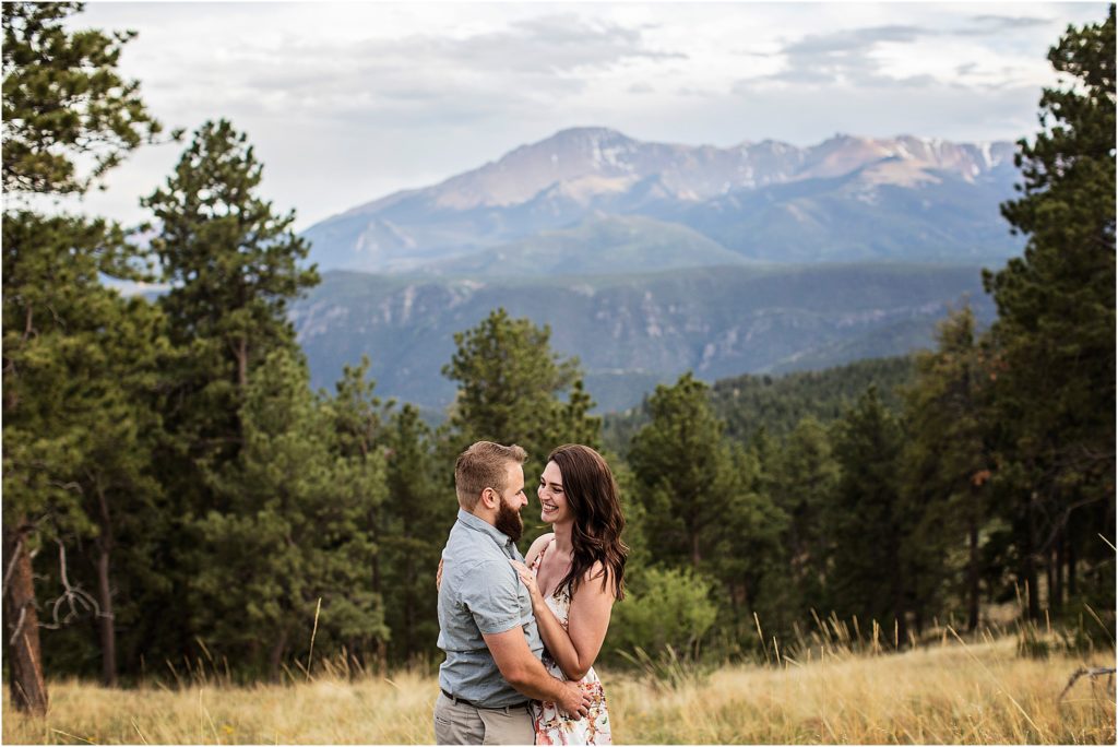 Colorado couple embrace for engagement photos with lovely mountain views.