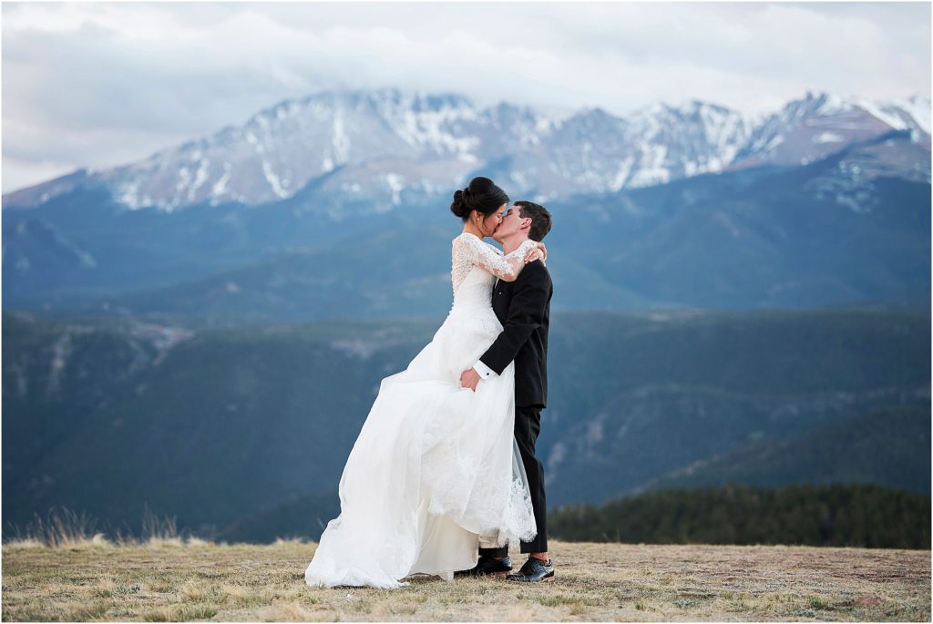 Adventurous couple take wedding photos on top of mountain in Colorado.