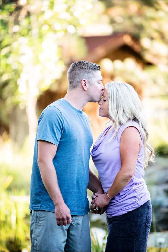Brian kisses Jordan on the forehead as they share a romantic moment on a sunny afternoon at a ranch near Colorado Springs