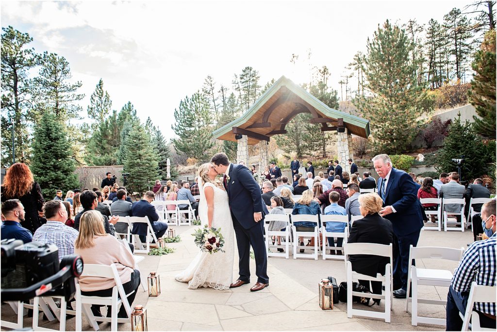 Bride and groom kiss at their outdoor ceremony at Cielo at Castle Pines.