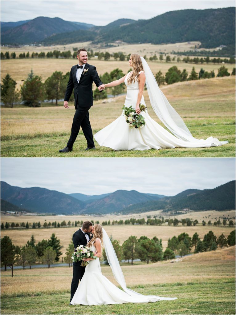 Bride and groom walk together and kiss in a field at Spruce Mountain Ranch in Colorado.