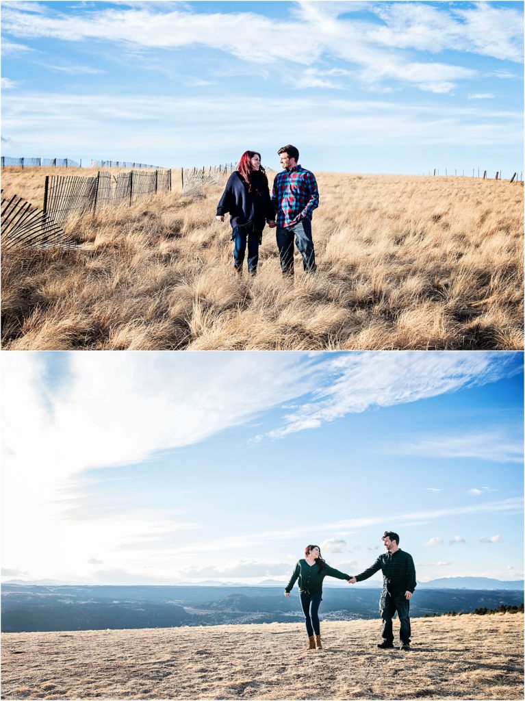 couple in love walk together holding hands in an open field with clear blue skies.