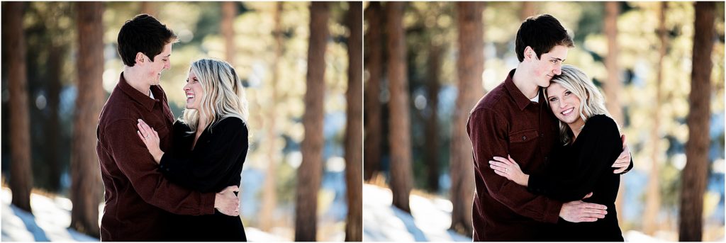 Young couple take engagement photos in a forest with snow on the ground.