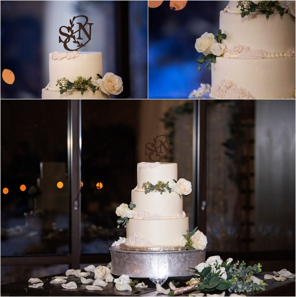 white wedding cake with white roses and other flowers on it