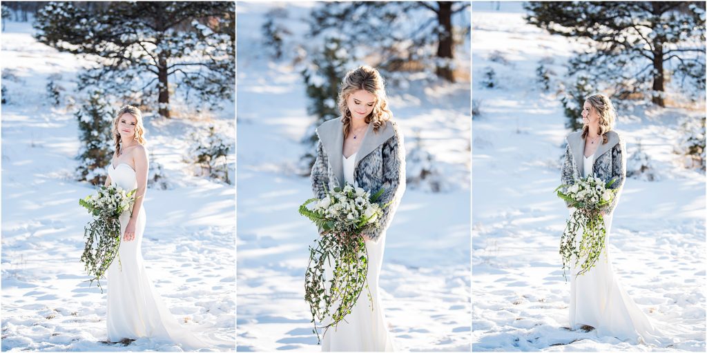 bride accessorizes with fur coat and white bouquet with hanging ivy at her winter wedding with snow.