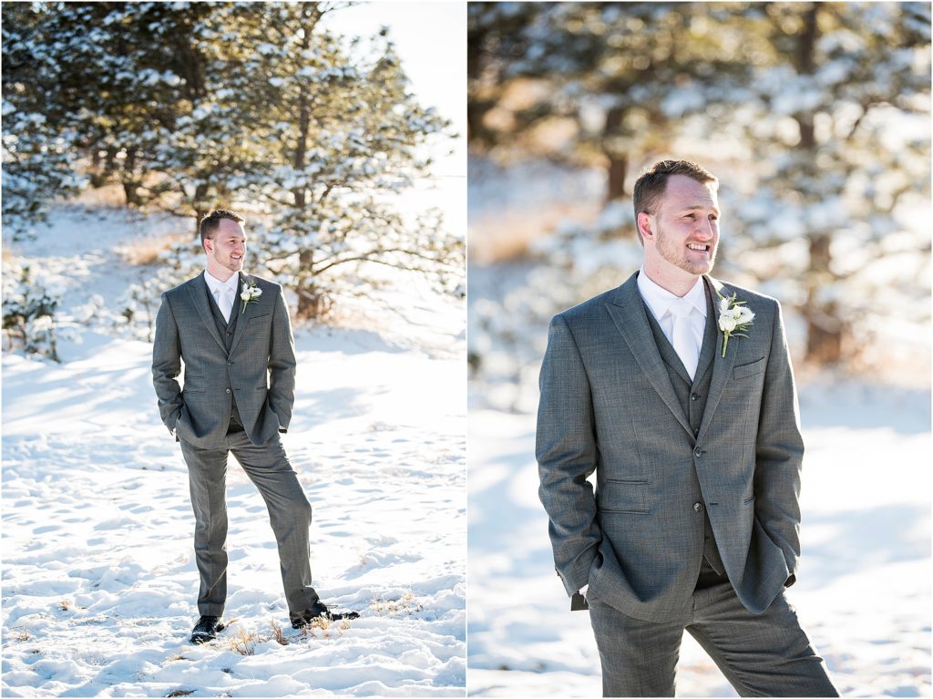 groom dressed in gray suite with white tie and white boutonniere in the snow at his wedding in winter