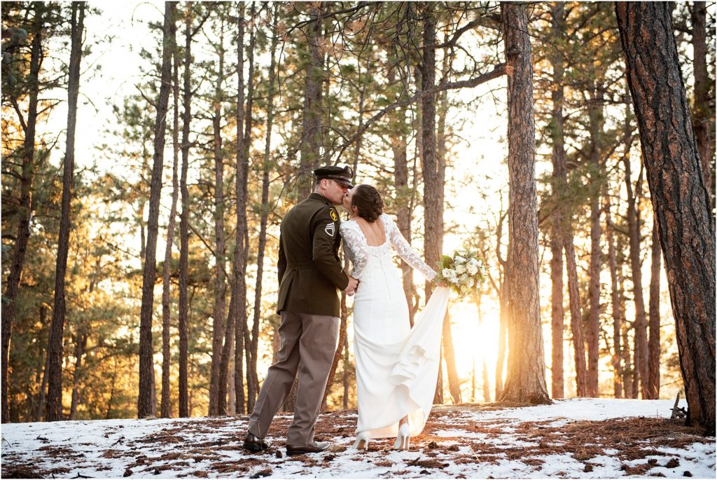 Bride and groom hold hands and kiss at their January wedding in Black Forest, Colorado.
