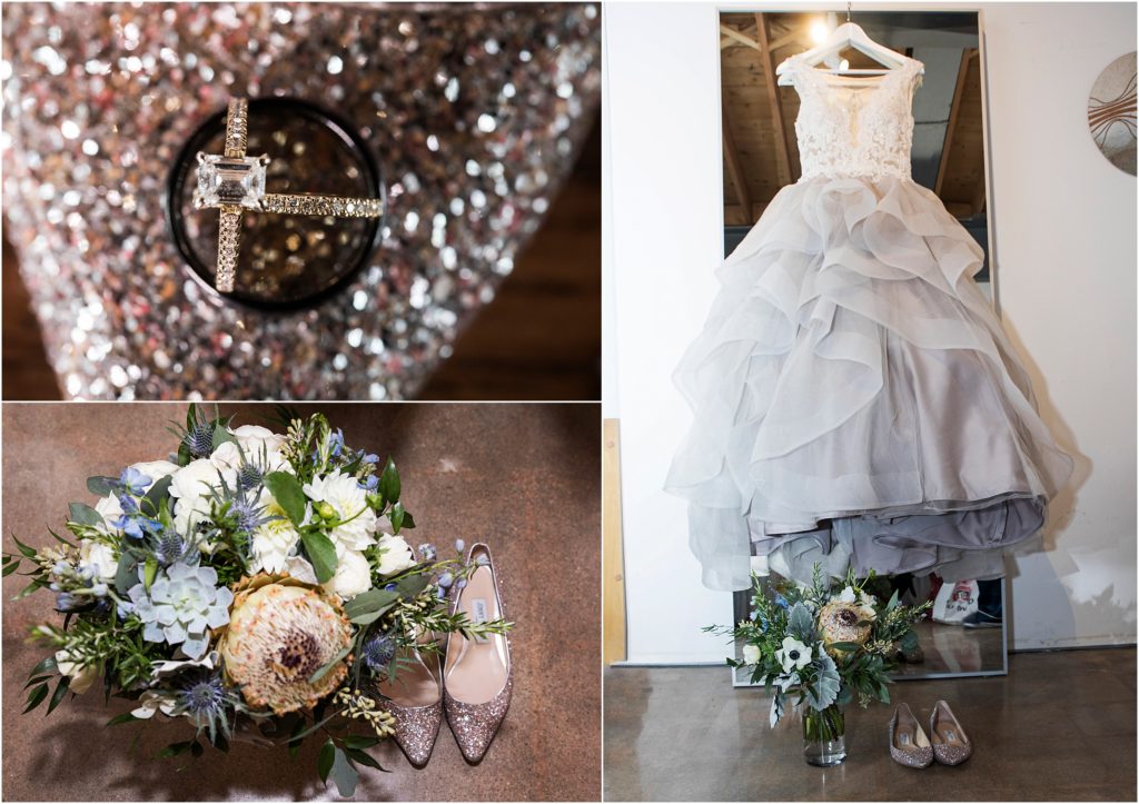 Dusty grey wedding gown hangs on a full length mirror with glitter flats and bouquet 