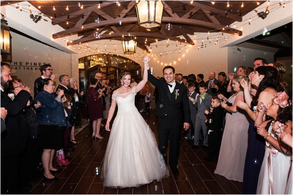 A happy couple celebrates their nuptials as they exit their reception to hundreds of bubbles in Colorado