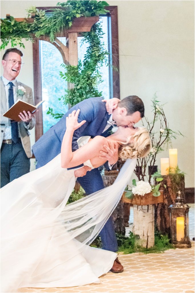 Groom dips bride as he gives her a kiss at the end of the ceremony.