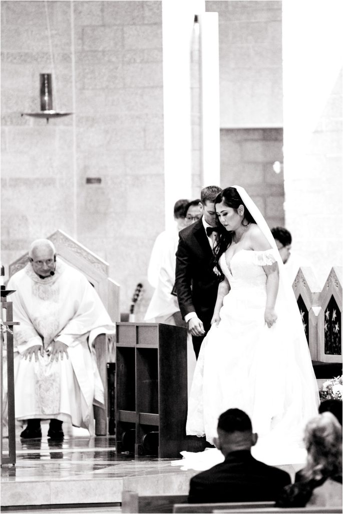 Touching wedding photograph captures the bride and groom in prayer at their wedding ceremony