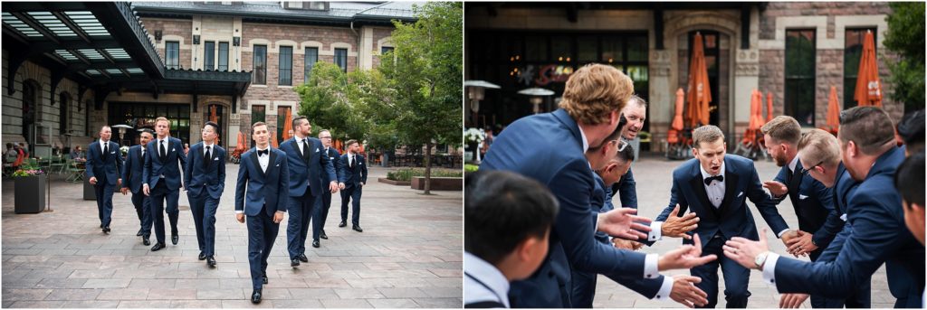 Outdoor urban wedding groomsmen walk in a v formation in black tuxedos, white shirts and black ties