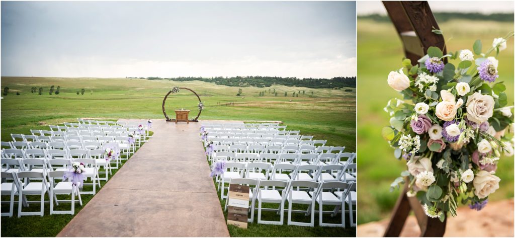 Circular wedding arch with simple floral arrangement is the backdrop to the outdoor summer wedding at Flying Horse Ranch, white chairs are set up in rows at the ceremony