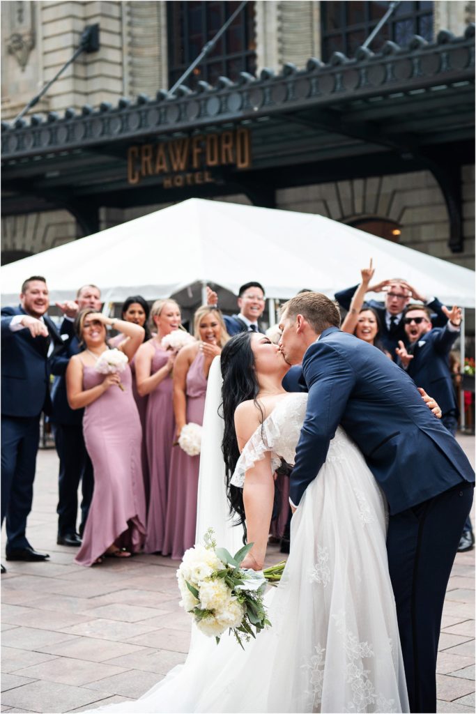 Groom dips bride for a kiss outside of the Union Station in Denver, Colorado summer wedding