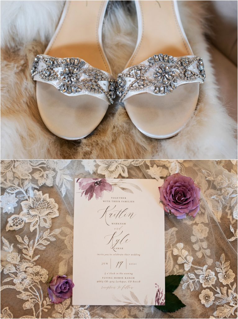 Elegant photo of bride's rhinestone studded heels set atop white fur and wedding invitation with cursive script and purple floral set atop lace
