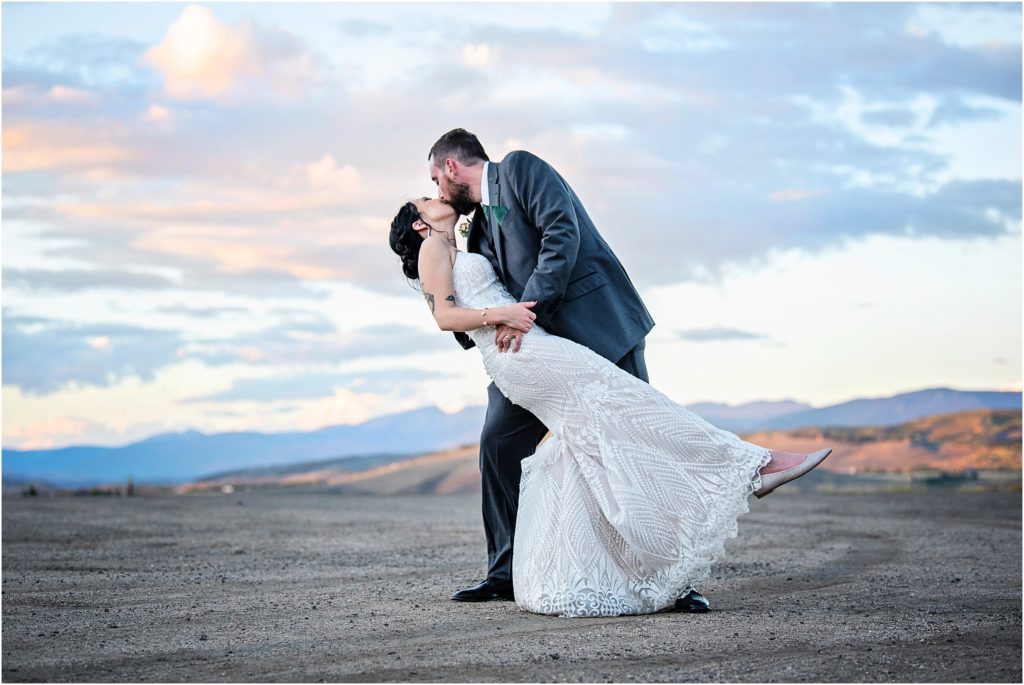 Colorado mountain range is the perfect backdrop for this wedding photo of the groom dipping his bride