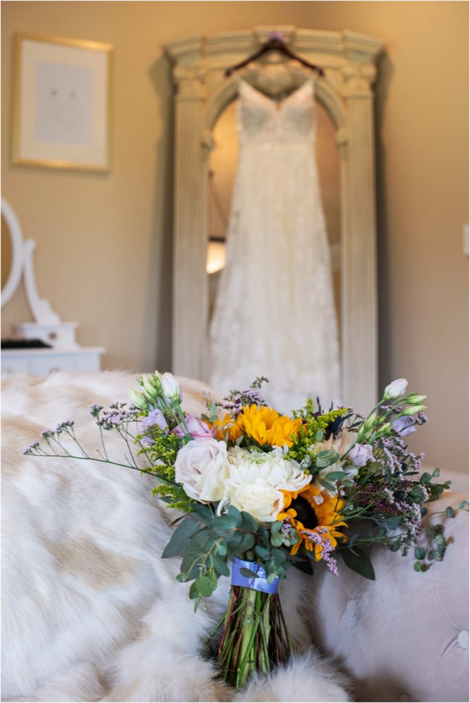 Wedding gown is beautifully displayed with the bride's bouquet in the bridal suite as part of the prewedding preparations