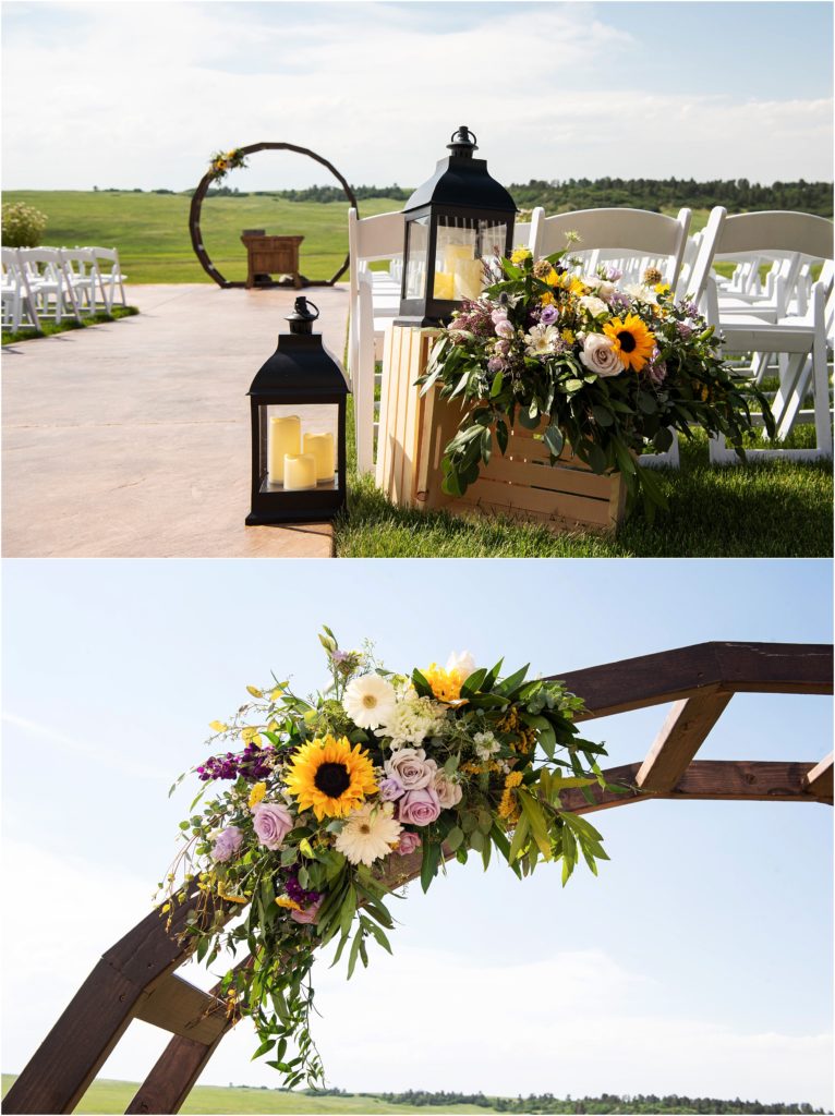 Gorgeous outdoor wedding ceremony at Flying Horse Ranch in Larkspur Colorado the wooden arch is highlighted by a summer floral arrangement with sunflowers, purple roses and greenery