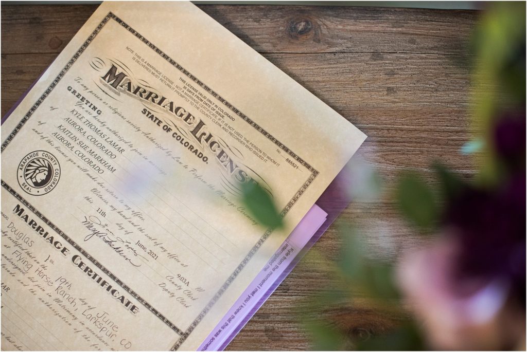 photographer captures a creative photo of the couple's marriage license highlighting the rustic decor