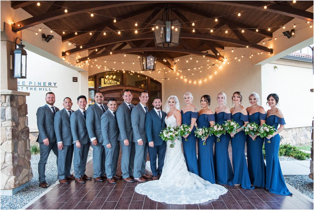 Bride and groom have a large bridal party wearing grey and blue at a wedding at the Pinery