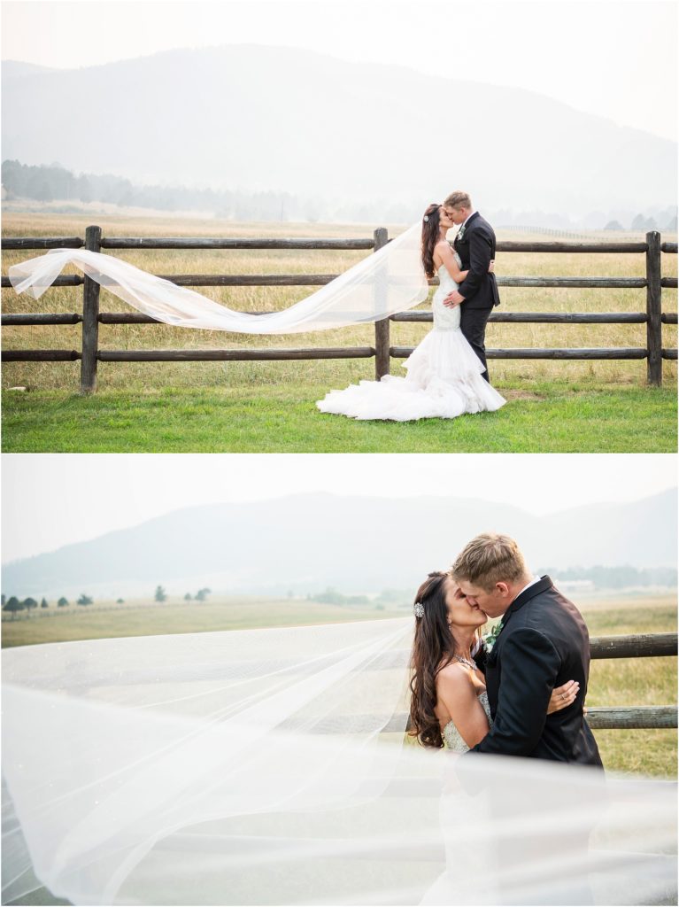 Brides veil flies in the gentle breeze as she kisses her husband on their wedding day at their ranch wedding in Colorado