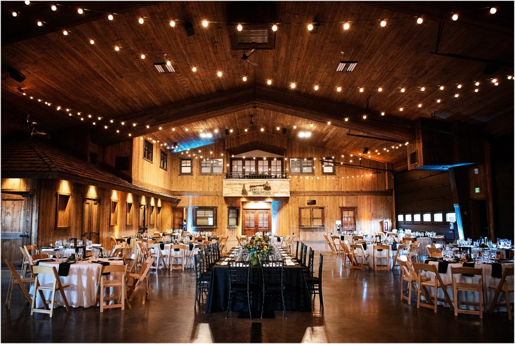 Wedding reception inspiration with a large head table and low light at Spruce Mountain Ranch with sunflower centerpieces