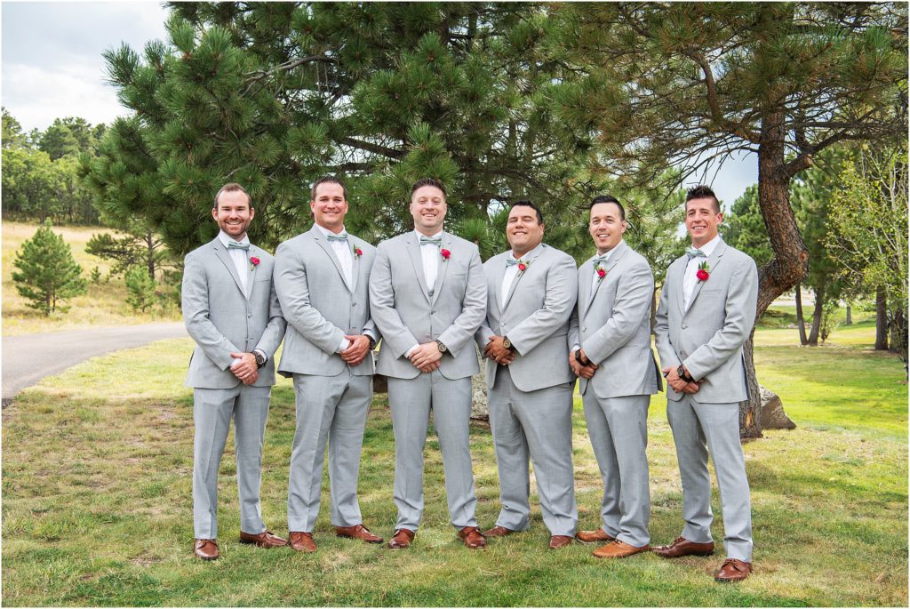 Groom stands with his 5 groomsmen at his summer wedding in Colorado