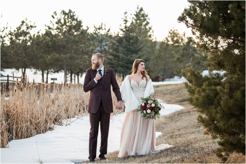 Snow lays on the ground as this bride and groom look around on their wedding day at Spruce Mountain Ranch in Colorado