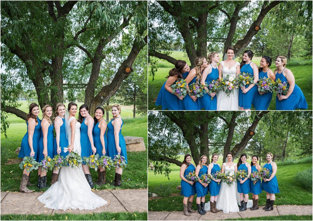 Bride stands with bridesmaids that are wearing boots and tea length teal dresses