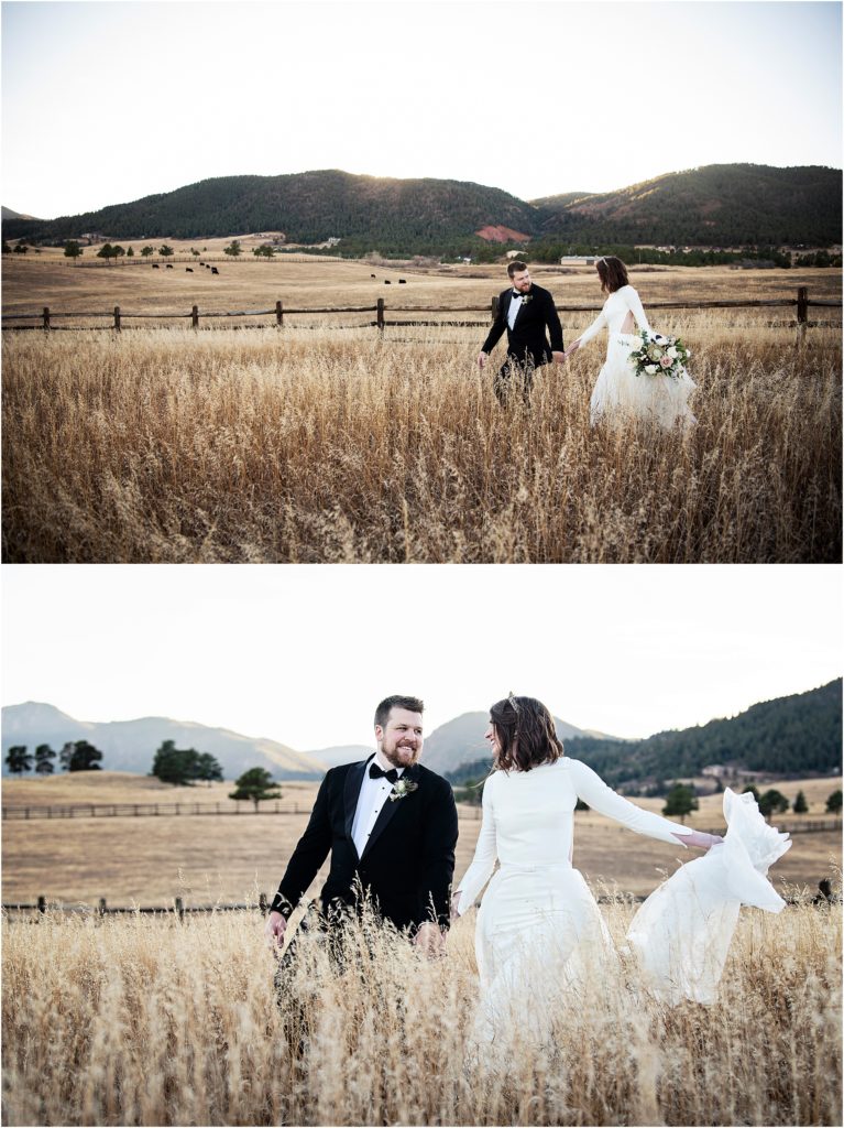 Bride and groom walk through field of tall dry wheat at sunset during their winter wedding