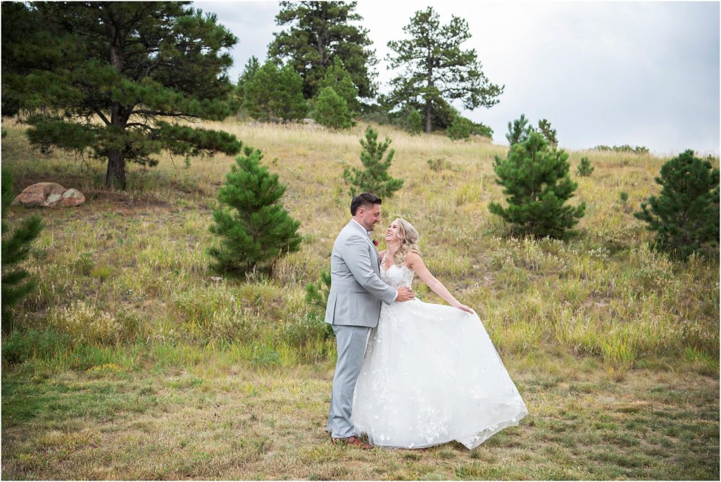 Colorado couple embrace each other and smile on their wedding day in summer
